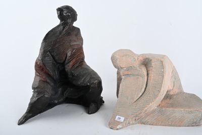 une statue représentant un homme assis sur une chaise, à côté d'une sculpture représentant un homme