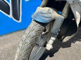 une moto blanche garée devant un mur recouvert de graffitis