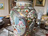 un grand vase posé sur une table recouverte d'un napperon