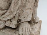 a statue of a woman sitting on a stone block