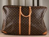 un sac Louis Vuitton marron et beige posé sur une table
