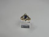 a close up of a ring with a blue stone in it