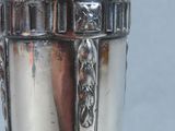 a silver vase that is sitting on a table