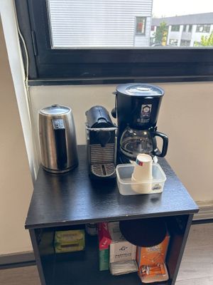 une petite table sur laquelle se trouvent une cafetière et une tasse