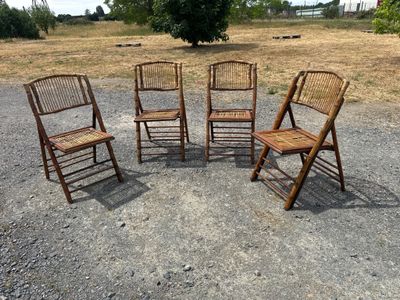 four wooden chairs are arranged in a circle on a gravel road