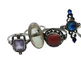 three different rings with different colored stones on them on a white background
