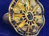 une image représentant une bague en or sertie de pierres noires et blanches