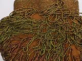 a brown beaded purse sitting on top of a white table