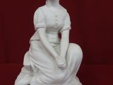 white statue of a woman sitting on a rock with a red background