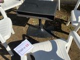 white plastic chairs and a table on the ground