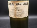 une vieille bouteille en verre vert, avec une étiquette, posée sur une table