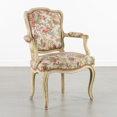 a chair with a floral upholstered back and arms