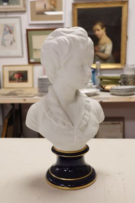 a bust of a woman sitting on a table in front of a painting