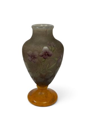 un vase sur lequel sont peintes des fleurs sur fond blanc
