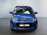 the small blue car is parked in a large room