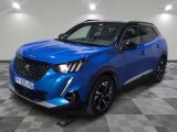 un 4x4 bleu garé sur un sol en damier dans un garage