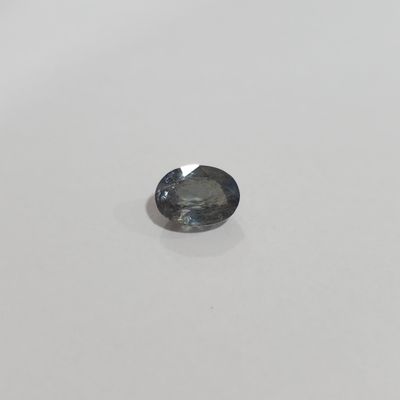 a blue sapphire stone on a white surface