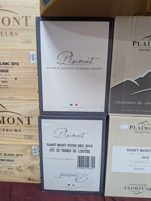 Plusieurs cartons de vin sont empilés les uns sur les autres sur une table