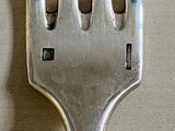 a silver fork with a small hole in the middle of it