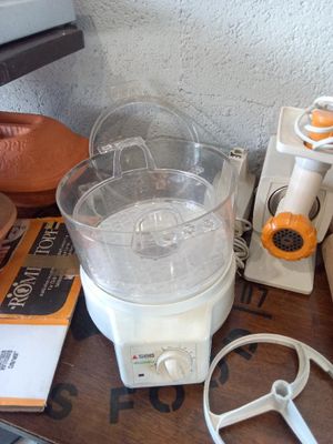 a blender sitting on top of a wooden table next to other items