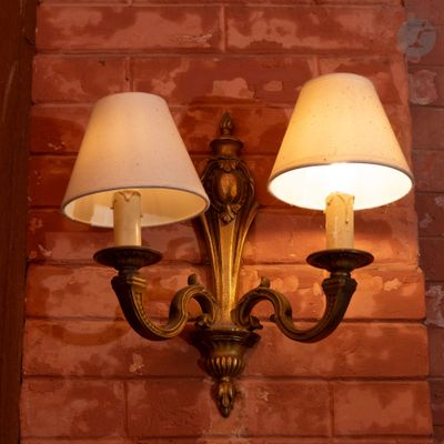 deux lampes accrochées au mur, à côté d'un mur en briques