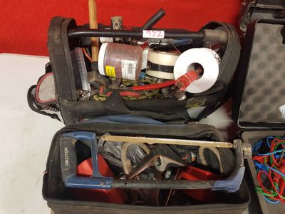 two open suitcases with tools in them on a table