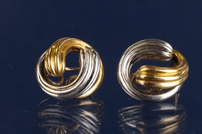 une paire de boucles d'oreilles en or et en argent sur un fond noir