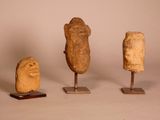 four pieces of art are displayed on wooden stands against a white background