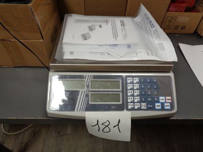 une calculatrice posée sur une table, à côté de cartons