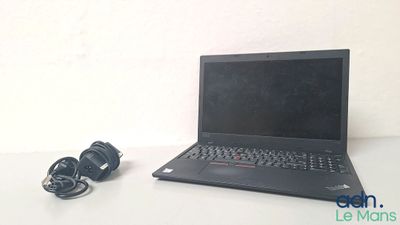 un ordinateur portable posé sur une table à côté d'un casque audio