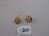 deux paires de boucles d'oreilles en or sur fond blanc, accompagnées d'une étiquette de prix
