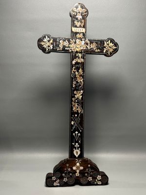 une croix en noir et blanc ornée de fleurs dorées