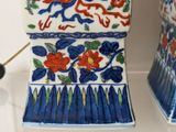 two blue and white vases with red flowers on them