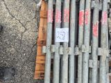 a pile of steel rods on the ground next to a person ' s shoes