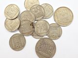 some old coins are scattered on a white surface