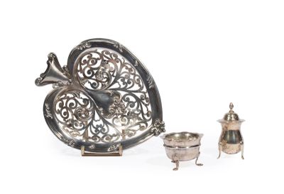 un plateau en argent orné d'un oiseau, posé à côté d'une théière en argent