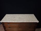an old dresser with marble top and drawers in a room