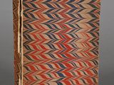 un vieux livre orné de motifs rouges, bleus et marron