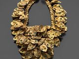 a gold necklace with turquoise stones and gold leaves