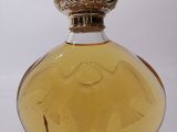 an image of a bottle of perfume sitting on top of a clear table