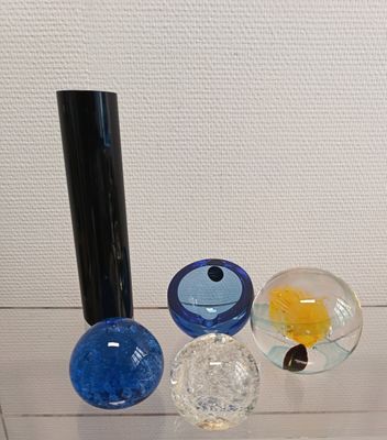 three glass vases sitting on top of a glass shelf