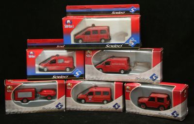 Plusieurs boîtes de petits véhicules rouges sont empilées les unes sur les autres.