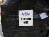 a sign that says noz retour noz on the back of a truck
