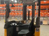 a forklift in a large warehouse with lots of pallets