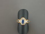 gros plan d'une bague en or avec une pierre bleue