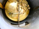 un gros plan d'une horloge dorée dans un récipient en métal