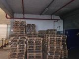 several pallets of wood stacked up in a warehouse area