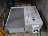 une pile de parpaings posée sur une palette dans un entrepôt