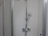 a shower in the corner of a bathroom with a glass door