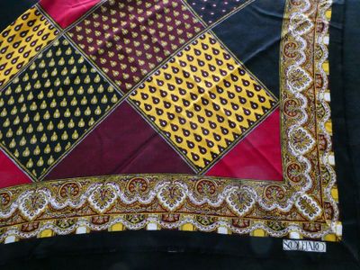 a close up of a red, yellow, and black scarf on a black background